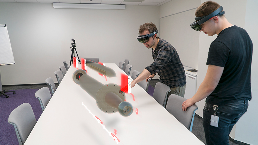 Two men using AR to work on a piece of virtual machinery
