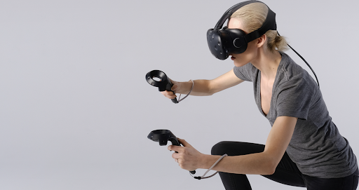 A woman crouched down, wearing a VR headset and controllers