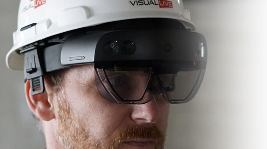 A man wearing a safety helmet with integrated AR headset