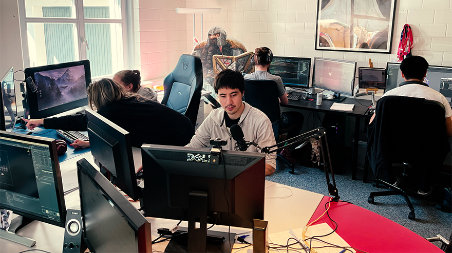 Five team members on workstations in an office
