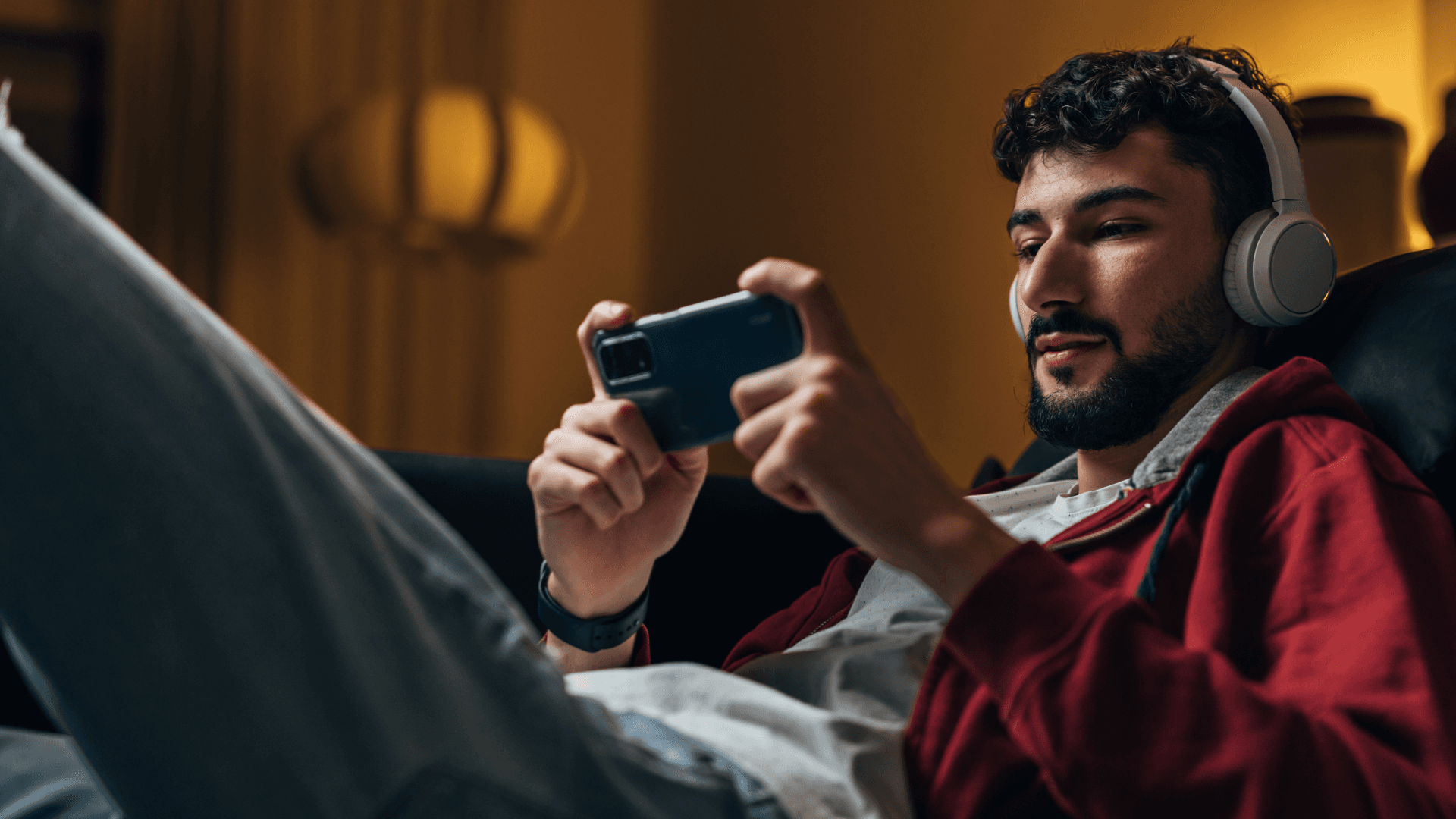 Person wearing headphones holding a mobile phone