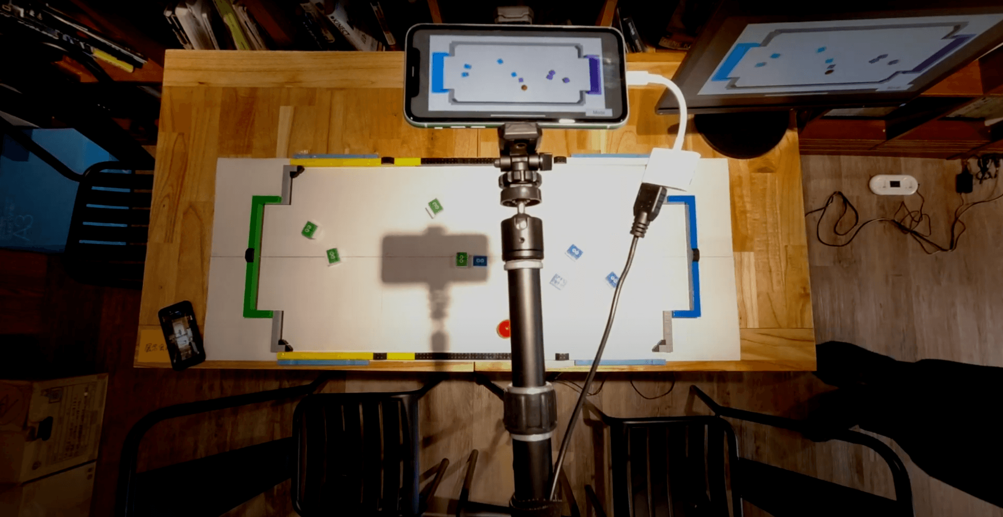 Demonstration of ML-Agents soccer with a soccer layout and lego ML agents and a red golf ball as the soccer ball