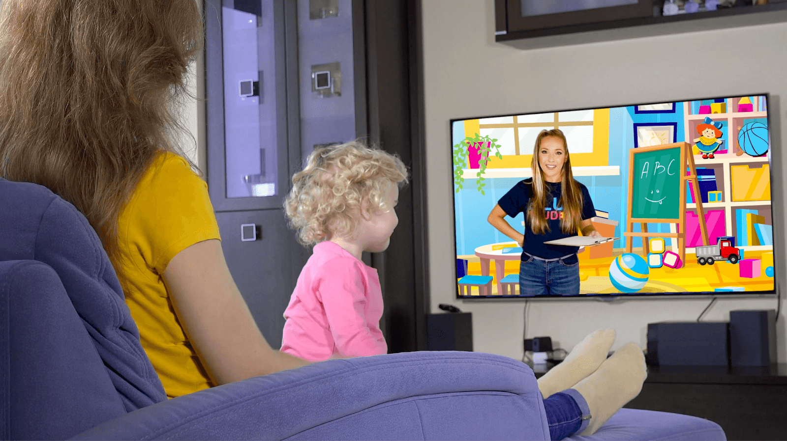 A person seated with a child in their lap, watching television