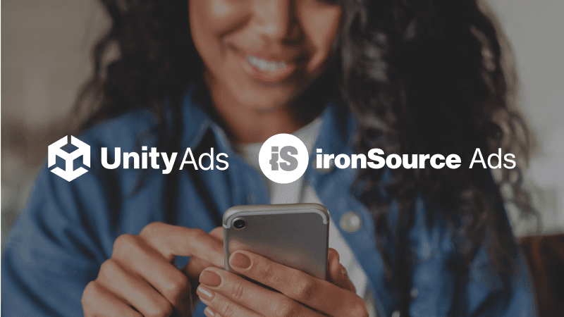 Pessoa ao telefone com os logotipos da UnityAds e da IronSource Ads na imagem