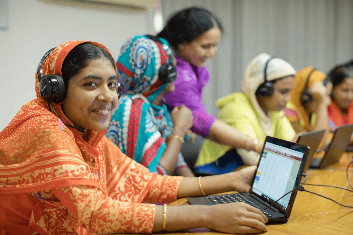 People wearing headphones while using laptop computers