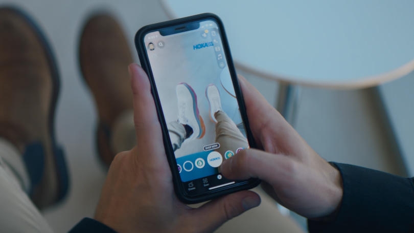 Pessoa usando a experiência de varejo em AR em dispositivo móvel para experimentar sapatos