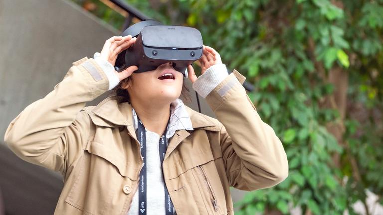 Woman excited while wearing virtual reality headset 