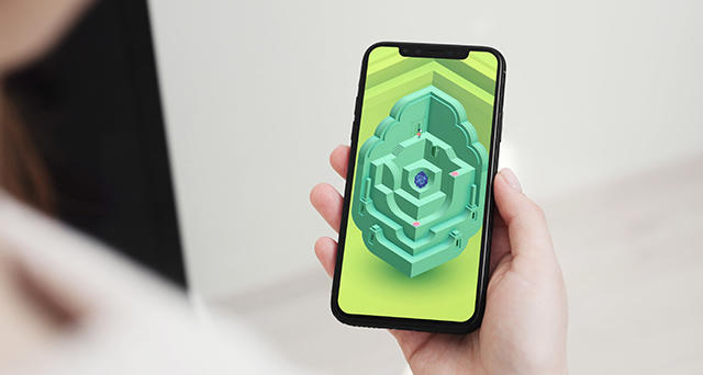 Hand holding mobile phone showcasing Monument Valley 2