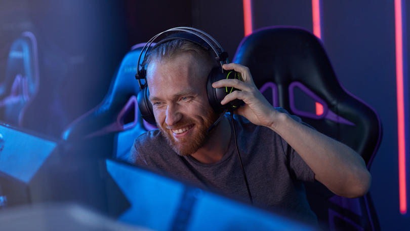 Man with headphones playing a PC game