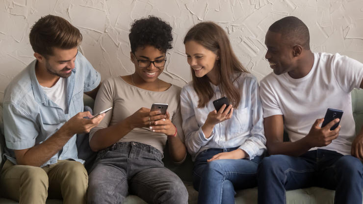 Eine Gruppe junger Erwachsener benutzen ihre Telefone