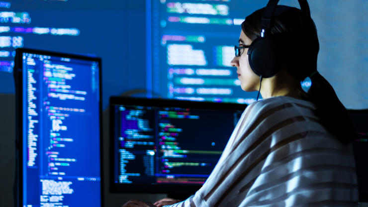 Женщина пишет код на компьютере