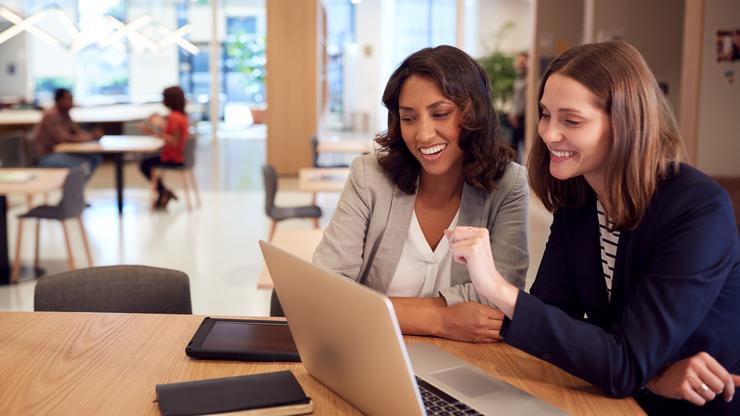 Two women collaborating in an open office space